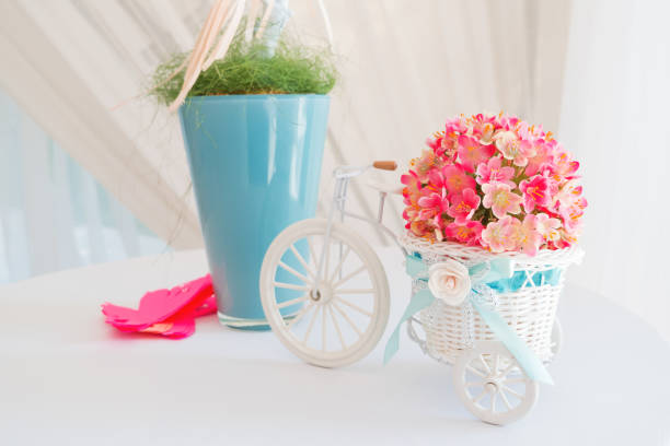 Decorative elements on wedding - white branch and decorative little bicycle with basket of flowers.