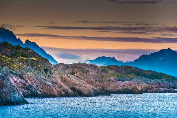 Stunning midnight sun coastal landscapes, Lofoten Islands, Nordland, Norway. Located north of the Arctic Circle. Known for its natural beauty, distinctive scenery with dramatic mountains and peaks, open sea and sheltered bays, beaches and untouched lands stock photo