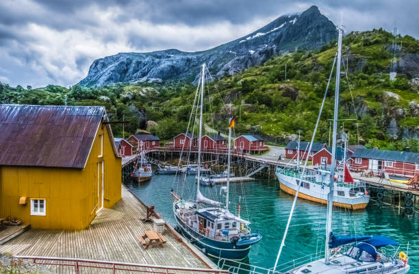 The charming village of Nussfjord, Lofoten Islands, an archipelago and a traditional district in the county of Nordland, Norway. Located north of the Arctic Circle. Lofoten is known for its natural beauty, distinctive scenery with dramatic mountains and peaks, open sea and sheltered bays, beaches and untouched lands as well as quaint picturesque villages. The islands have for more than 1,000 years been the centre of great cod fisheries, especially in winter, when the cod migrates south from the Barents Sea and gathers in Lofoten to spawn el encantador pueblo de nussfjord, islas lofoten, nordland, noruega. ubicado al norte del círculo polar ártico. conocida por su belleza natural, el paisaje distintivo con espectaculares montañas y picos, abrir mar y bahías protegidas, playas y tierras vírgenes así