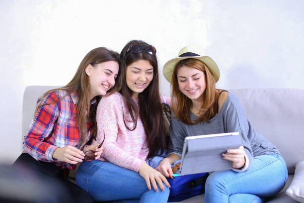 istock Close female friends use tablet and have fun, sit on couch in ro 840250026