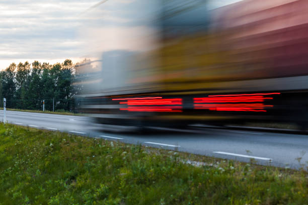 istock Speeding motion blur oncoming trucks with glowing lights on the highway after sunset. Abstract blur image background with copy space. 840254326