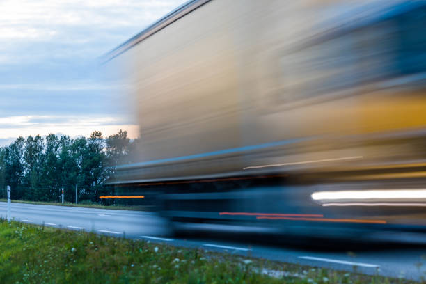 istock Speeding motion blur oncoming trucks with glowing lights on the highway after sunset. Abstract blur image background with copy space. 840255228