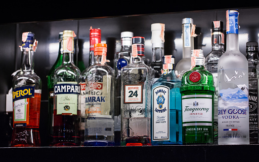 Una variedad de bebidas alcohólicas, Bernd, se colocan en los estantes en el bar para cócteles. photo