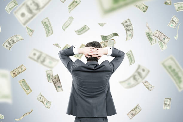 istock Businessman with hands behind head in money flow 840273100