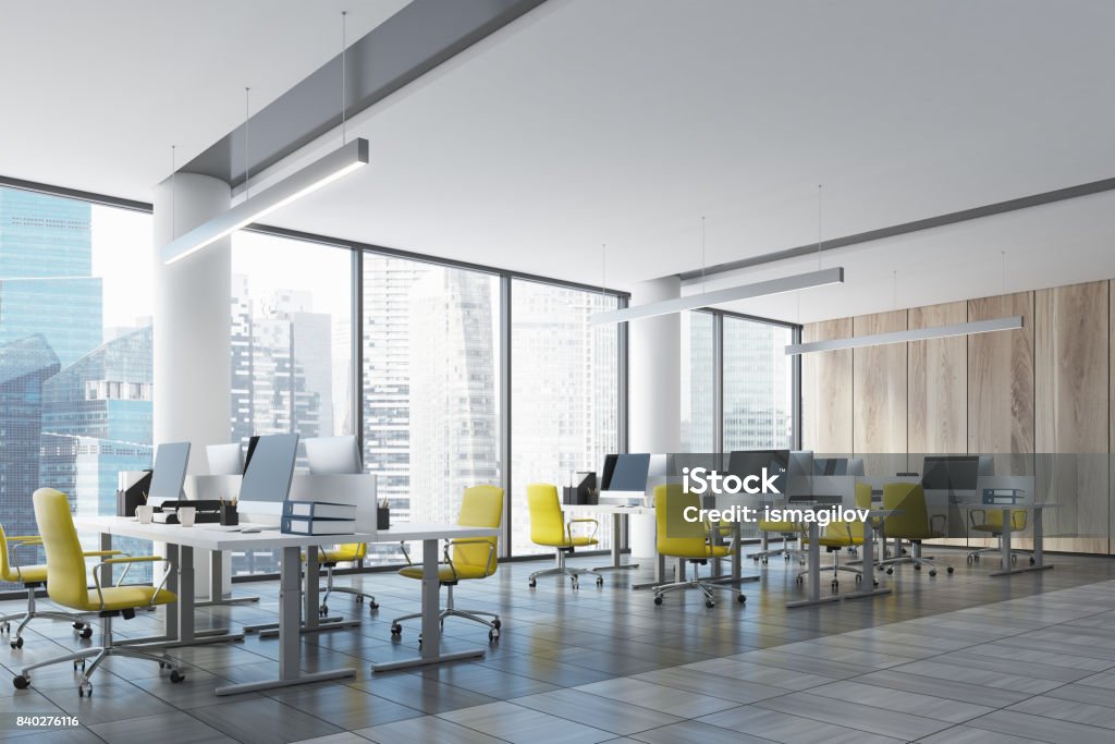 Loft open office with a wooden wall, side Wooden wall open space office interior with panoramic windows, columns and rows of tables with computer monitors on them. Side view. 3d rendering mock up Office Stock Photo