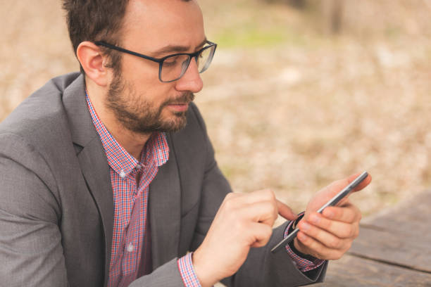 istock Business man sitting outdoors and using his cellphone. 840276154