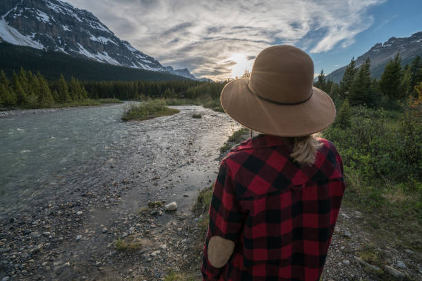 istock Female admiring nature by the river at sunset 840282904