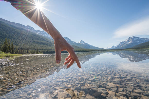 istock Finger touches surface of mountain lake 840285866
