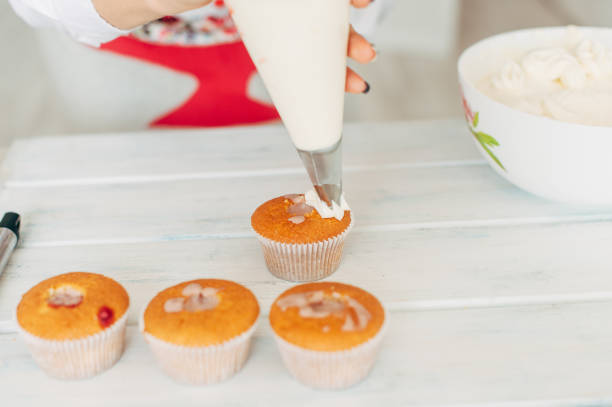 istock A young girl decorates cupcakes with cream. 840289138