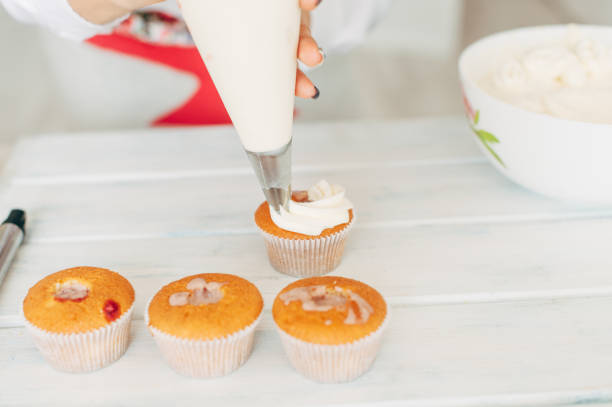 istock A young girl decorates cupcakes with cream. 840289194