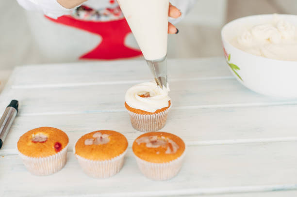 istock A young girl decorates cupcakes with cream. 840289240