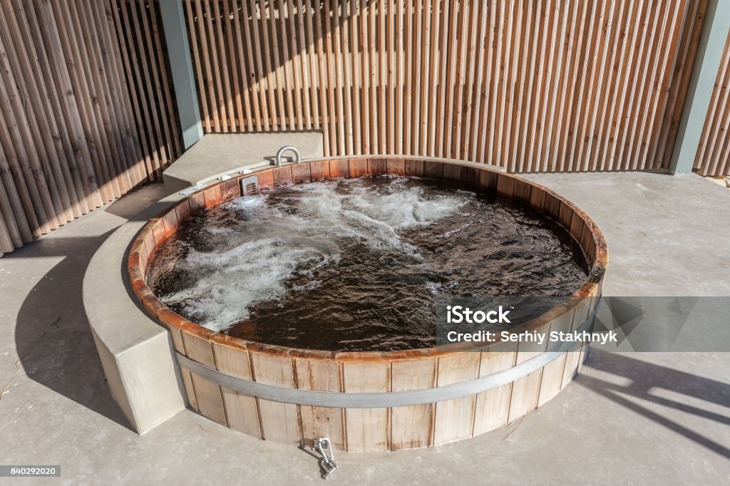 Wooden hot tub is filled with water on outdoor Wooden hot tub is filled with water on outdoor. Summer Hot Tub Stock Photo