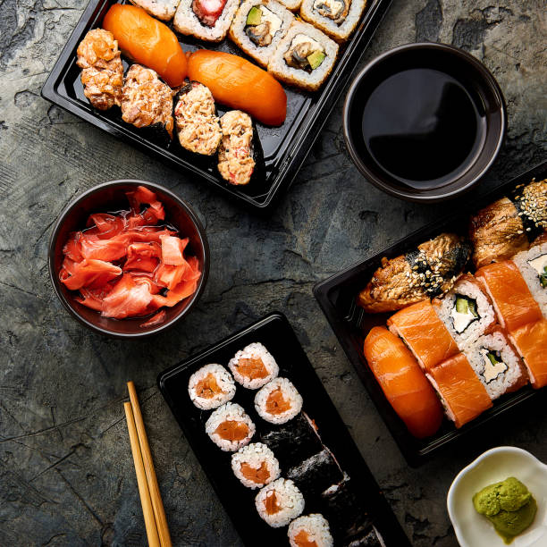 istock Variation of sushi and rolls on stone table. Sushi rolls, sashimi set with chopsticks. Top view with copy space. 840294110