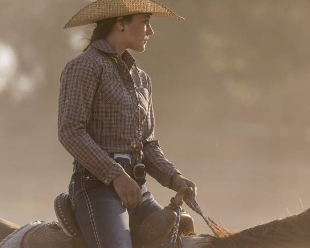 close-up of a beautiful young cowgirl horseback riding on a utah ranch. - cowgirl imagens e fotografias de stock