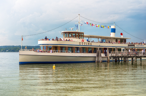 Passenger ship in Ammersee, big bavarian lake near Munich - August 27, 2017: Picturesque view of an old Steamship with passengers in the water of Ammersee lake in summertime. Image, taken in 27/08/2017 in Ammersee, Bavaria, Germany