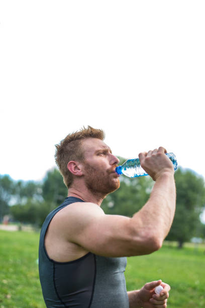 istock Close up of a man drinking water from a bottle outside 840316634