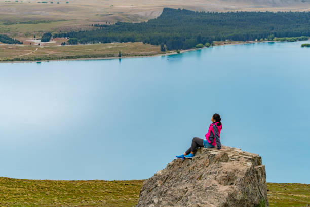 frau reisenden am lake tekapo, neuseeland - lupine single flower flower blue stock-fotos und bilder