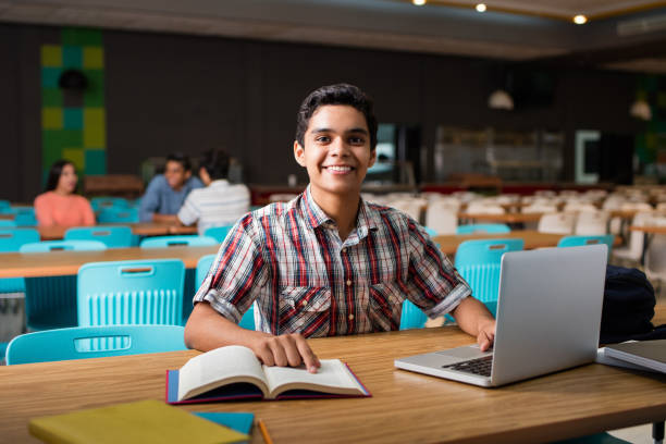 istock Male student sitting with laptop computer and book 840340620