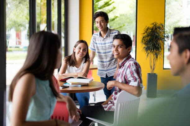 istock College students sitting at different tables and smiling 840341378