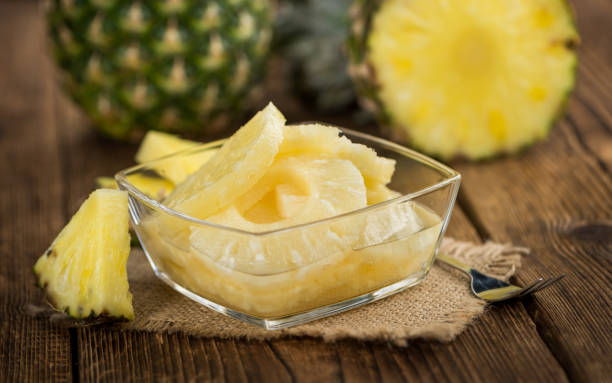 istock Wooden table with Preserved Pineapple Rings, selective focus 840370870