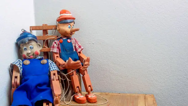 Photo of Two pinocchio puppet made from wood.