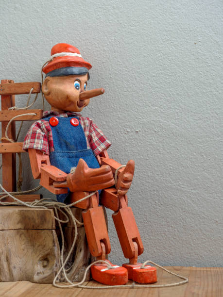 istock Pinocchio puppet made from wood.Sitting on wood box 840388462