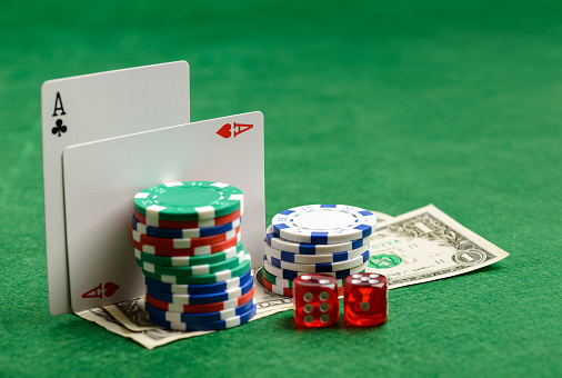 Casino green table with play cards, chips, money and dices. Poker game concept