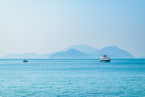 Landscape view of sea ocean with speed boat and mountain in sunny day.