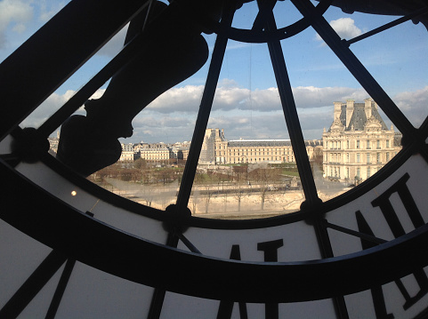 An unusual view of Paris trough the glass of an enormous clock.