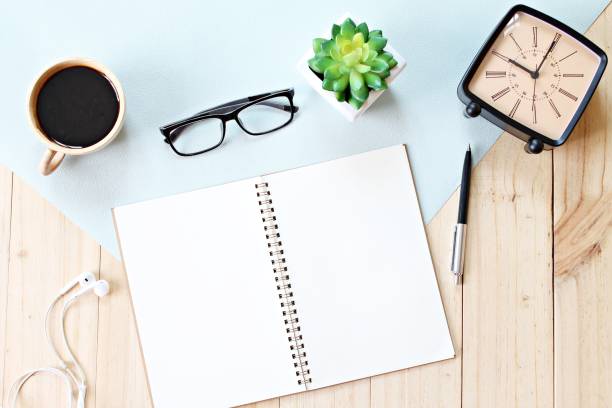 istock Top view or flat lay of open notebook paper with blank pages, accessories and coffee cup on wooden background, ready for adding or mock up 840393532