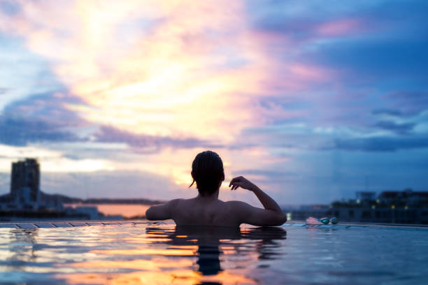 istock a man relax in the pool under sunset sky in summer 840395968
