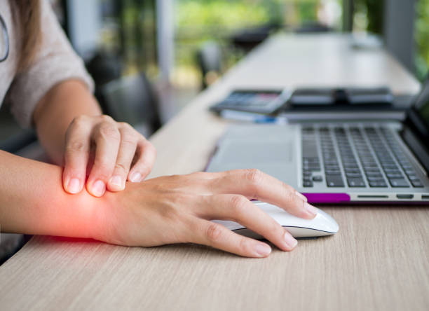 donna da primo piano che tiene il dolore al polso dall'uso del computer. sindrome dell'ufficio dolore alle mani per malattia professionale. - wrist foto e immagini stock