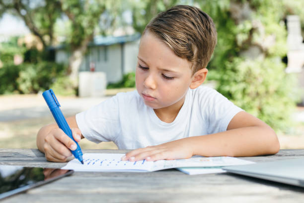 istock Little boy doing homework in garden 840404064