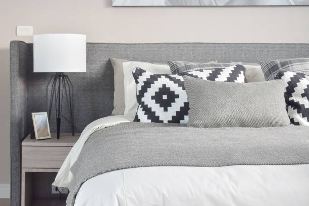 istock Graphic pattern and grey shade pillows on the bed with modern style reading lamp 840404736