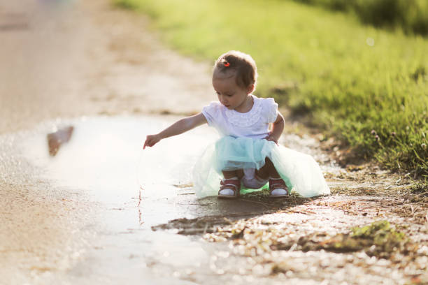 Side view of girl playing in muddy water.