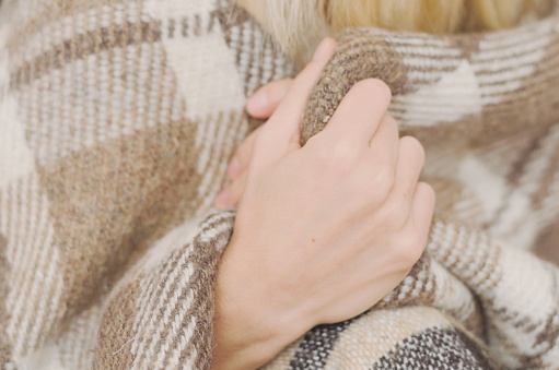 Girl wrapped in a warm wool plaid if natural colors