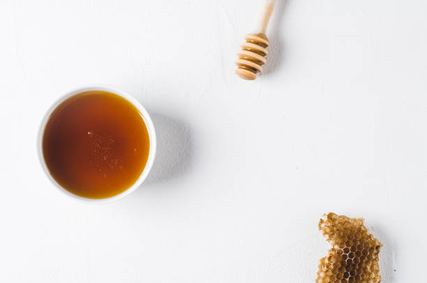 istock Fresh honey in a white cup on a white concrete background 840419226