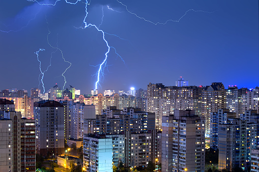 A lot of large lightning bolts in the sky above the city. Wonders of nature.