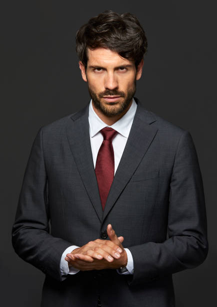 istock Serious young businessman with hands clasped 840428040