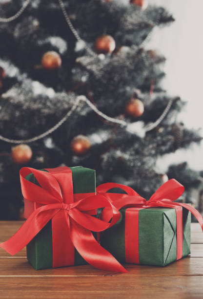 istock Christmas presents on decorated tree background, holiday concept 840430968
