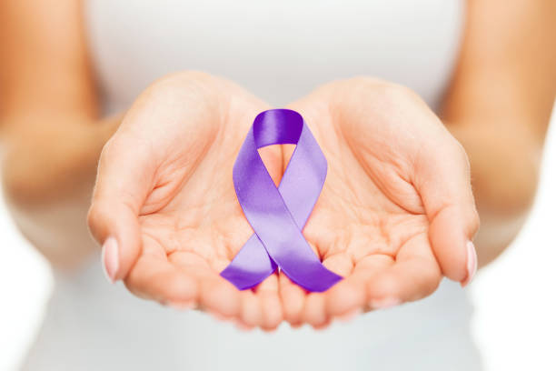 mains tenant le ruban violet sensibilisation - purple ribbon photos et images de collection