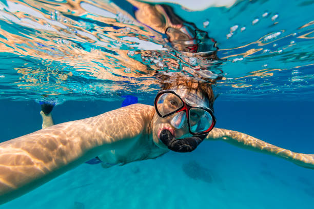 istock Young man enjoying snorkeling underwater. Selfie portrait 840436824