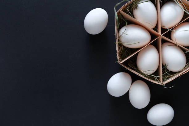 istock Fresh chicken white eggs in carton on black background 840440344