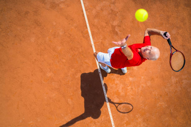 seniorzy biorąc na świecie, usługi tenisowe z góry - tennis serving playing men zdjęcia i obrazy z banku zdjęć