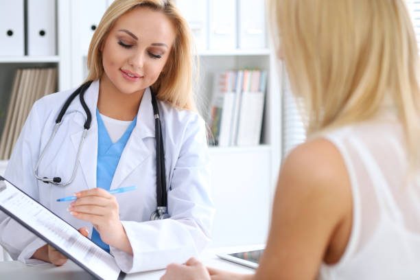 istock Doctor and  patient  discussing something while physician pointing into medical history form at clipboard 840450496