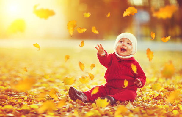 istock happy baby boy throws autumn leaves and laughs 840451558