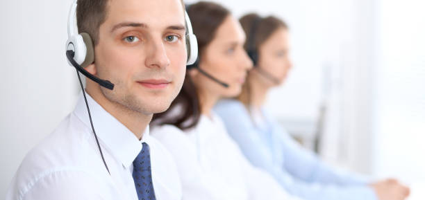 istock Call center operators. Focus at businessman in headset while consulting customers 840457474