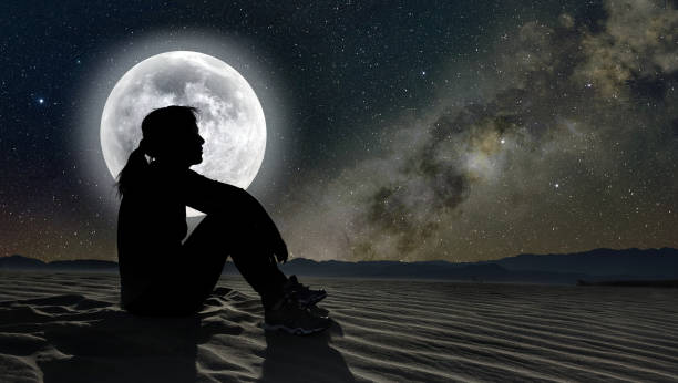 istock female silhouette sitting in the moonlight 840465652