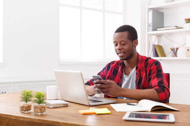 istock Young black businessman with mobile phone in modern white office 840468778
