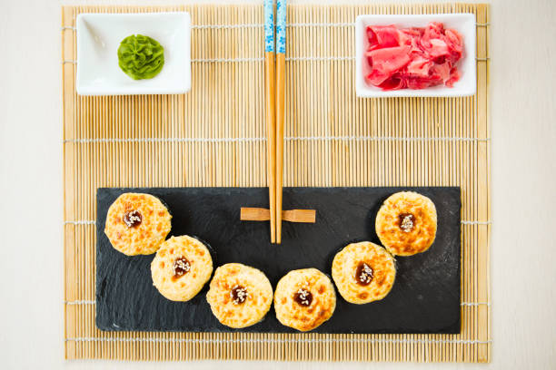istock Hot sushi rolls served on black slate surface. Japanese food 840472282